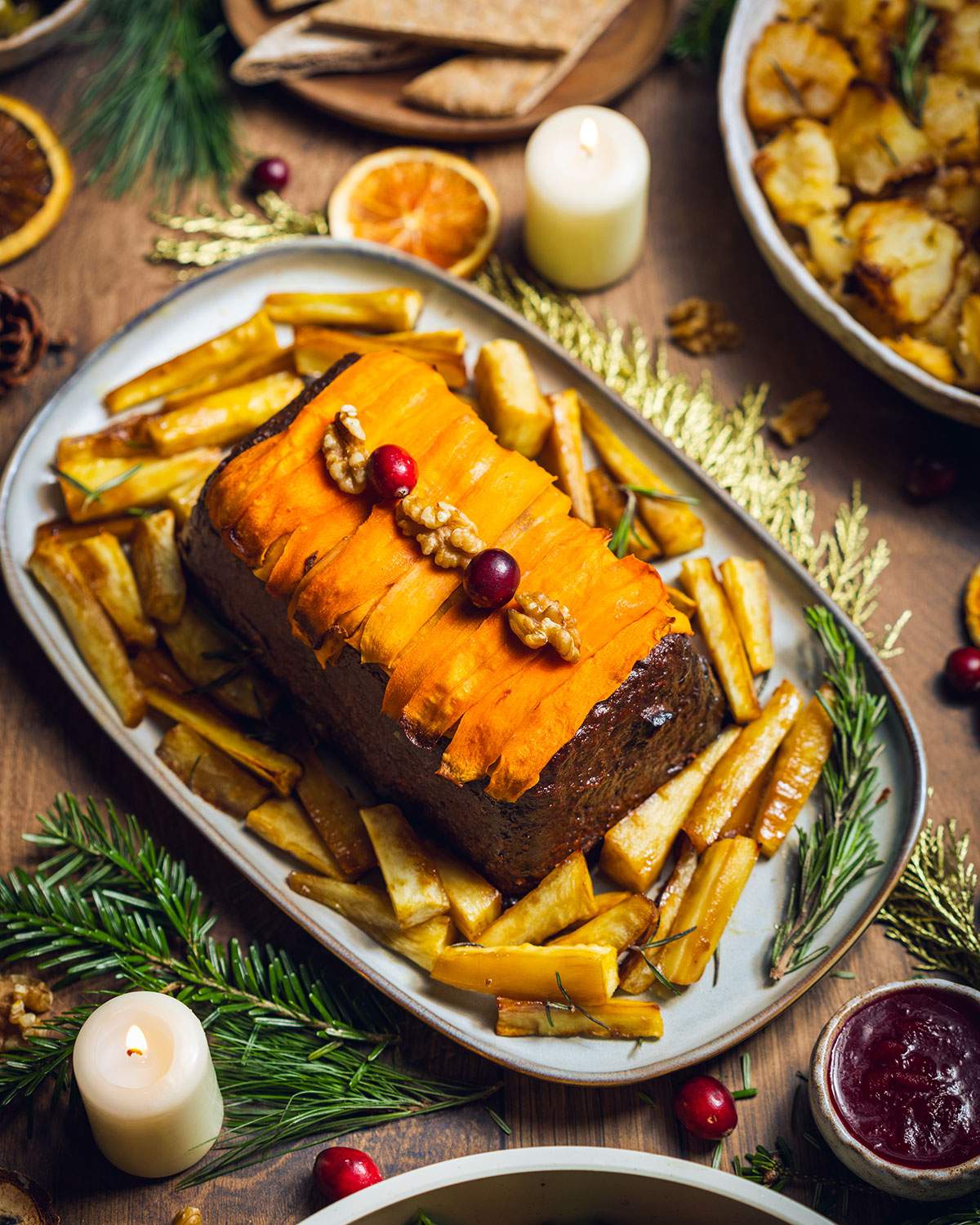 A serving dish with a vegan lentil walnut roast decorated with carrots.