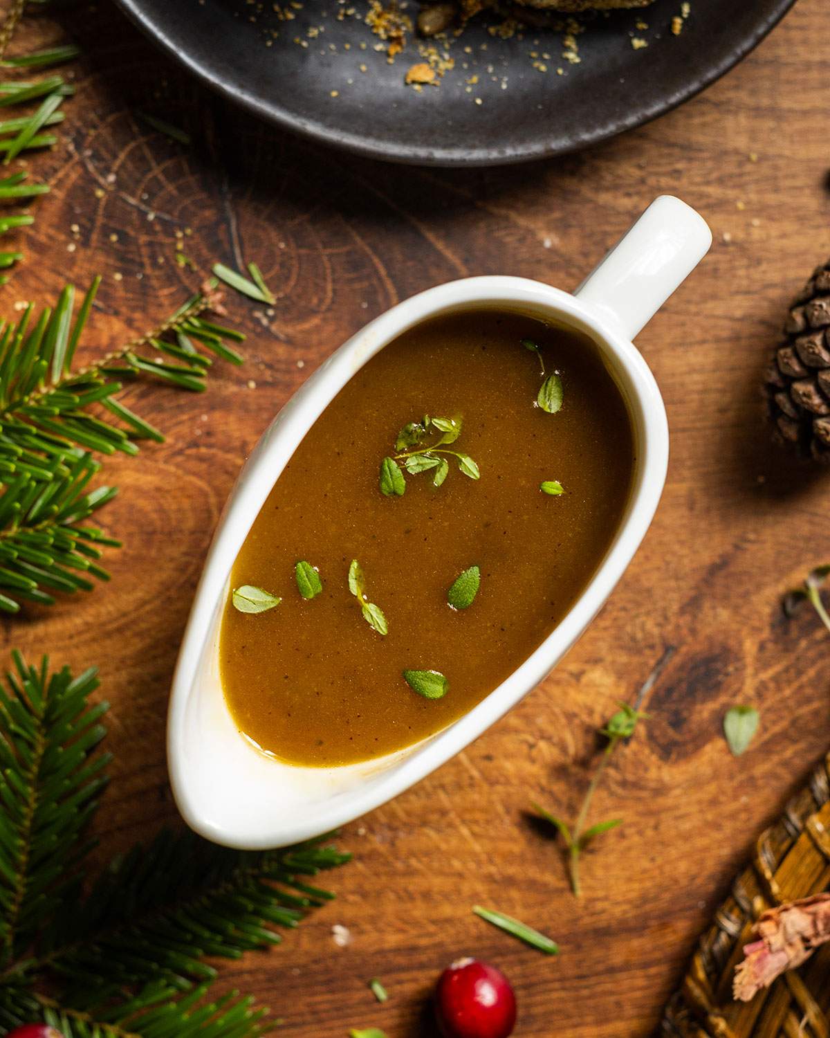 Vegan Shallot gravy in a gravy boat on a wooden table.