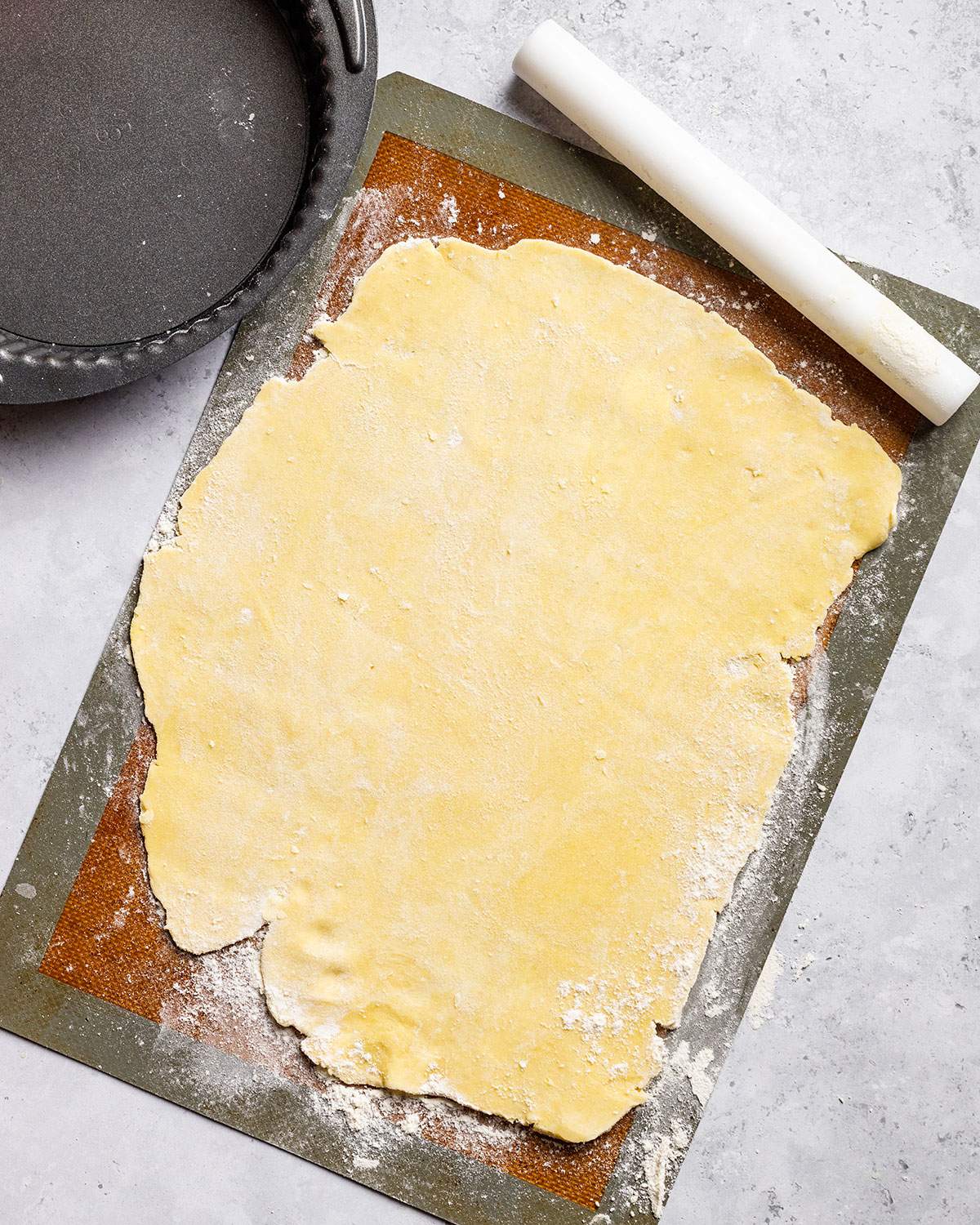 Vegan shortcrust pastry rolled out on a baking mat.