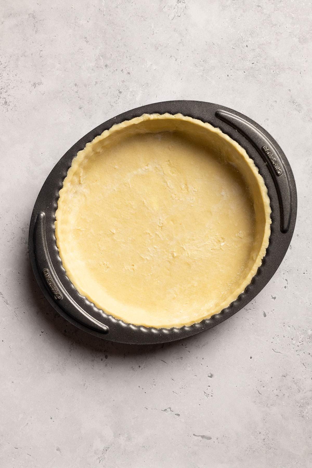 Vegan tart base in a tart tin before baking.