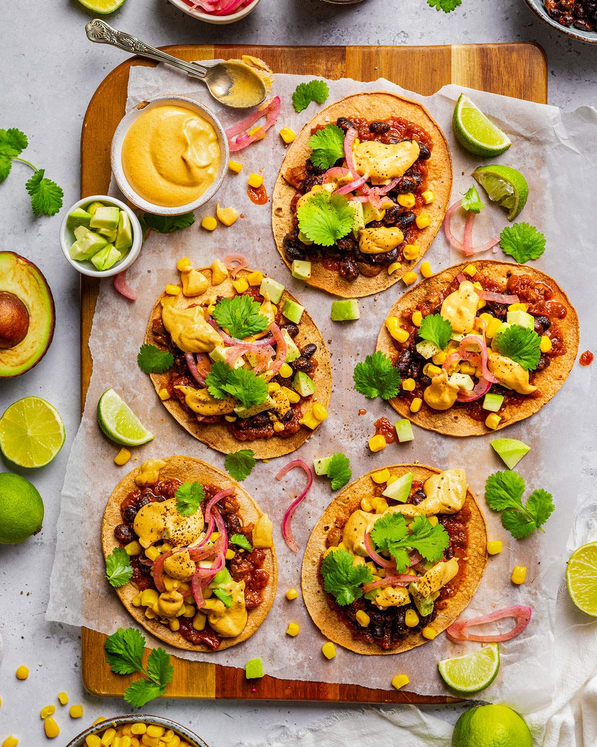 Vegan Tostadas with Black Beans and vegan nacho cheese sauce on a serving platter.