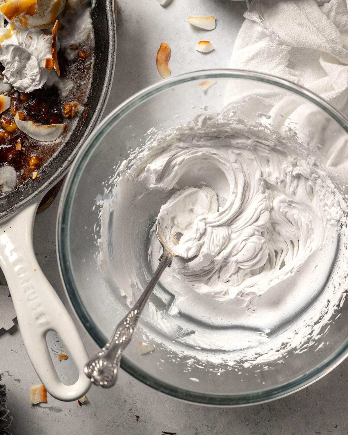 Whipped coconut cream in a bowl with a spoon.