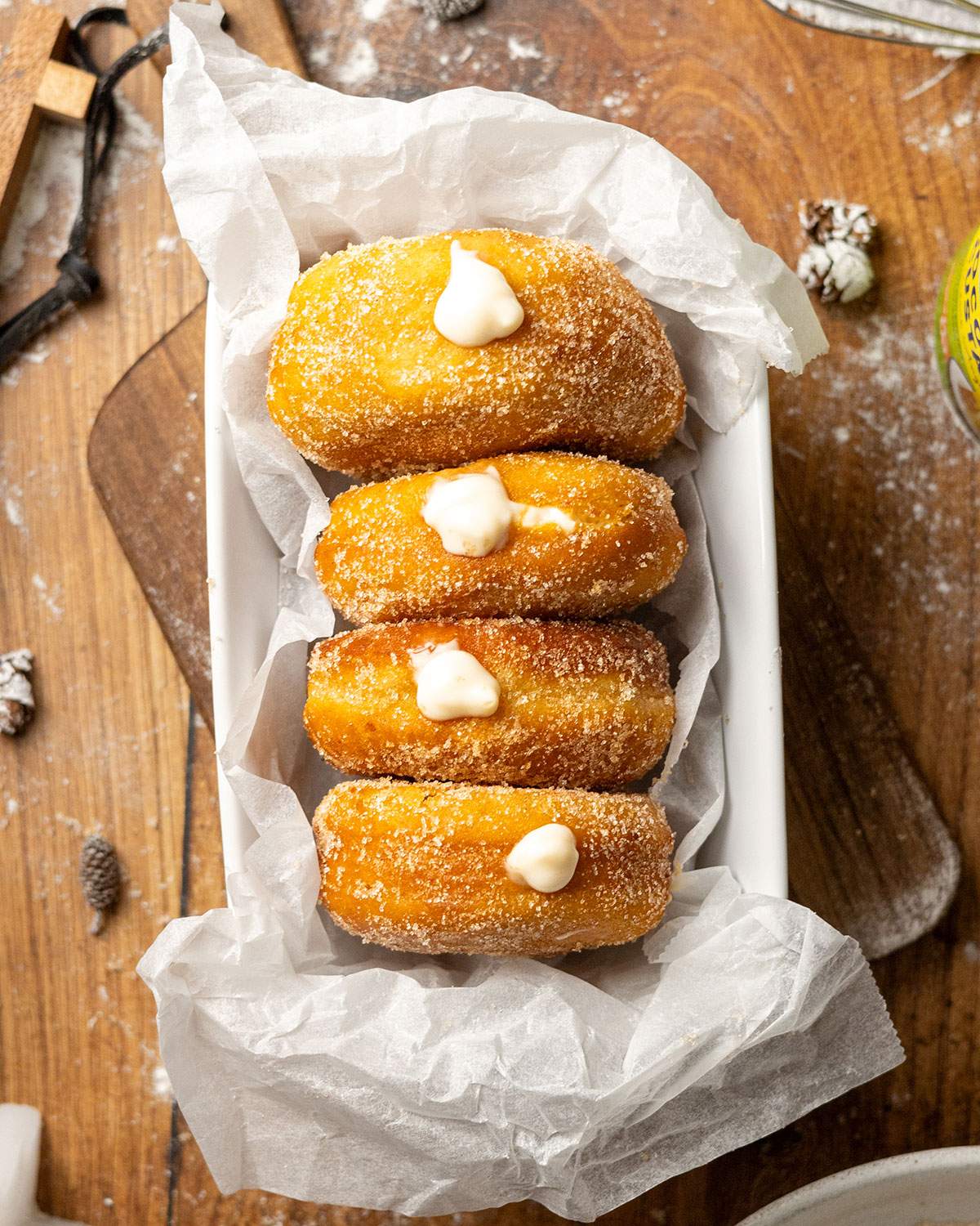 Four vegan donuts filled with custard in a tray.