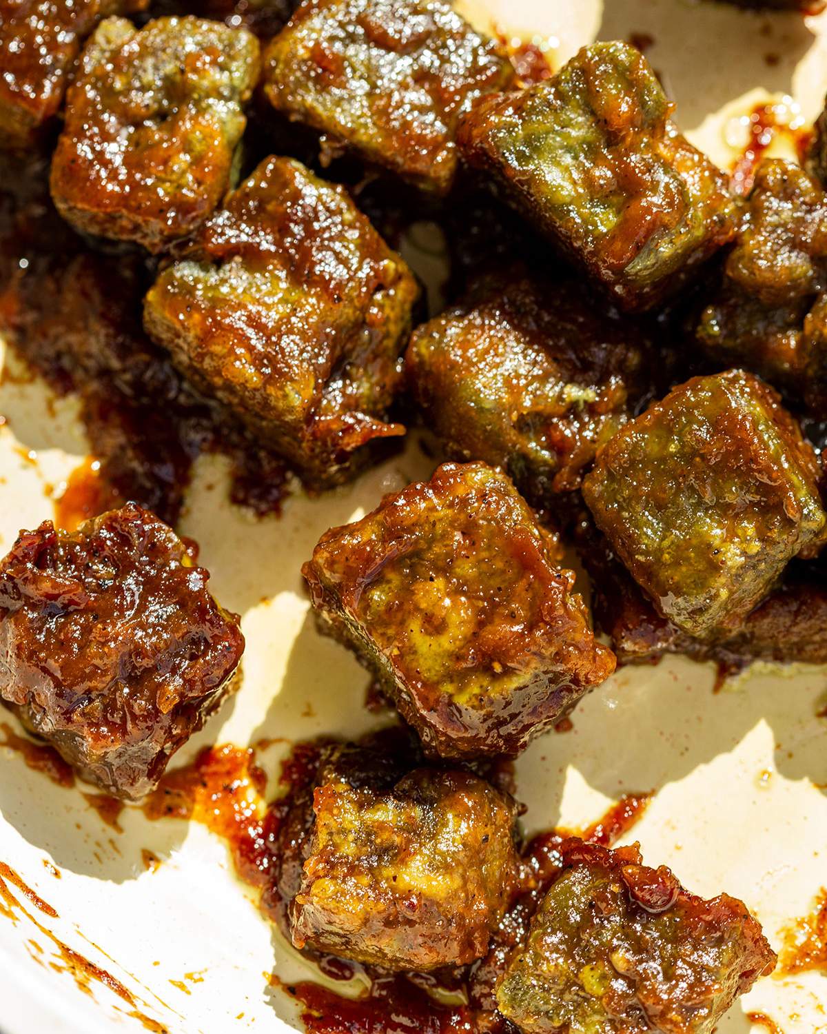 Crispy coated pumfu tofu cubes in a skillet.