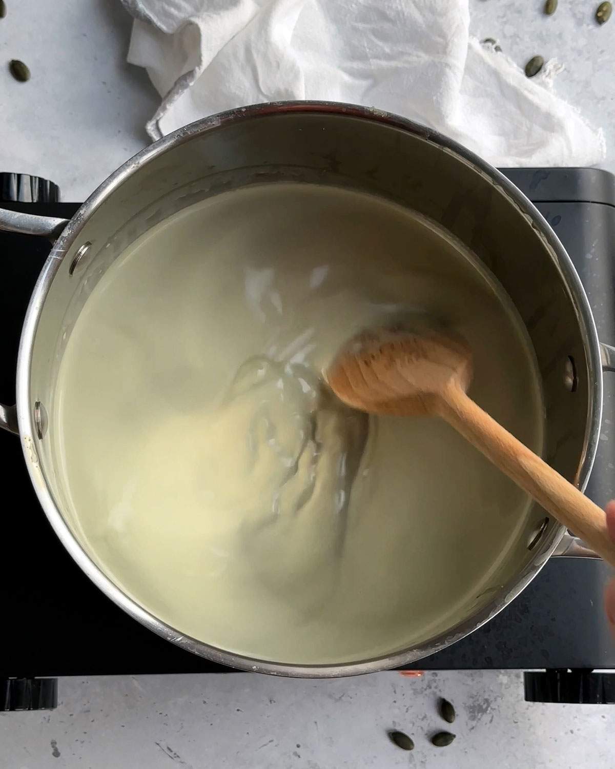Stirring pumpkin seed milk on the stove.