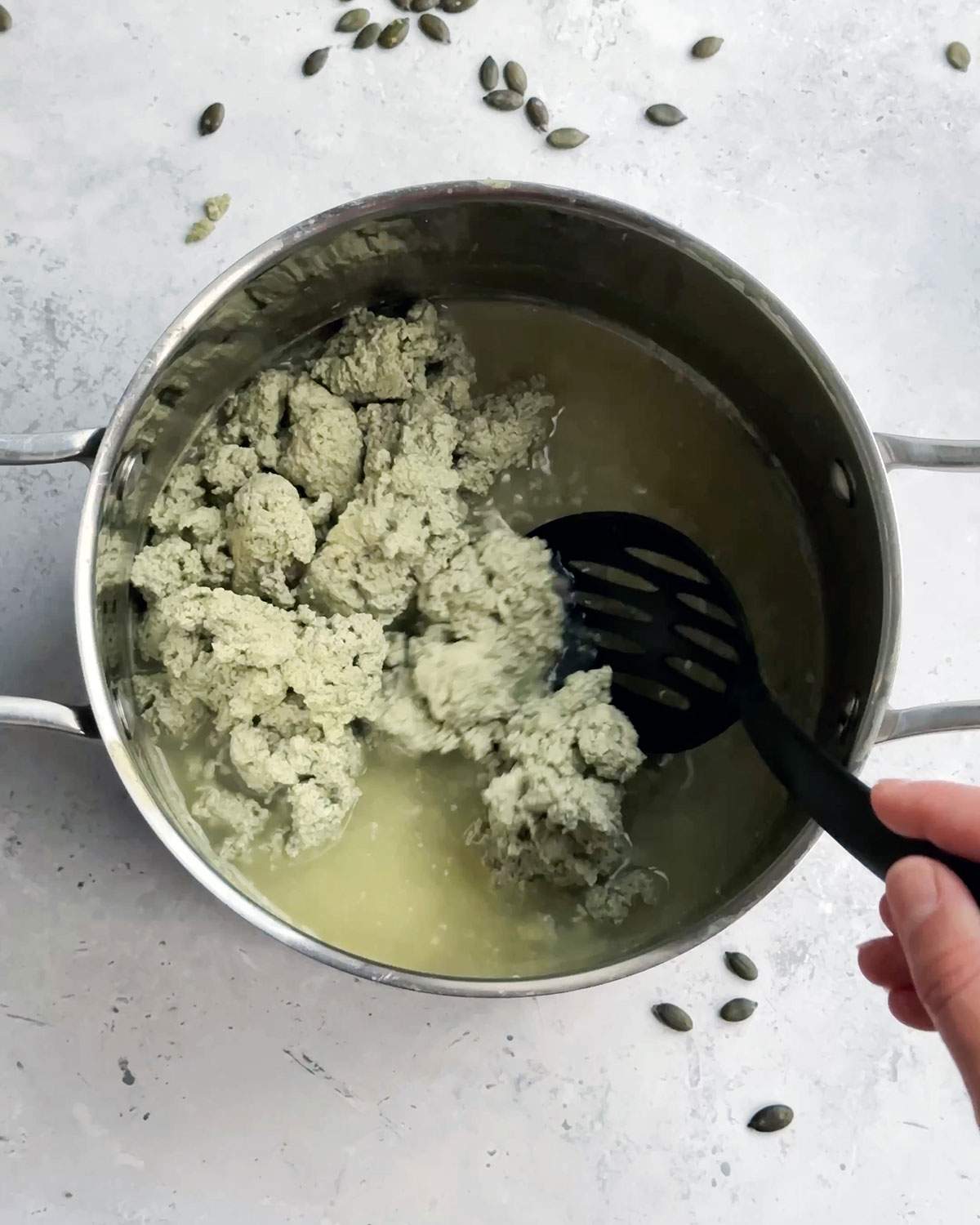 Picking up pumfu curdles from saucepan.