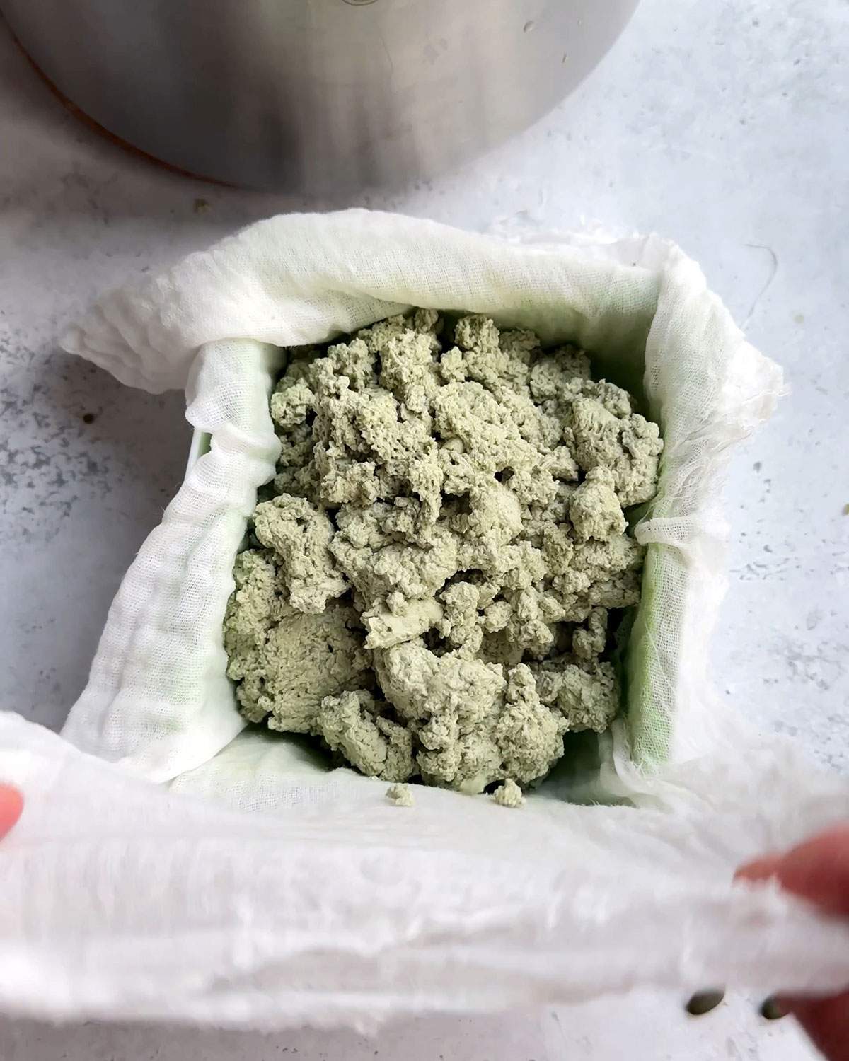 Pumfu curdles in a tofu press with a cloth.