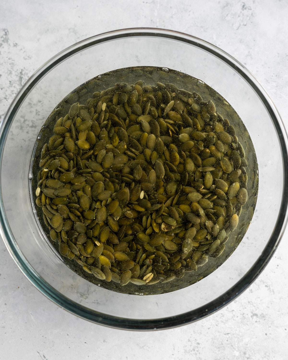 Soaking pumpkin seeds and water in a glass bowl.