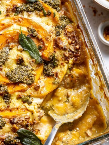 A serving spoon in a butternut squash gnocchi casserole dish.
