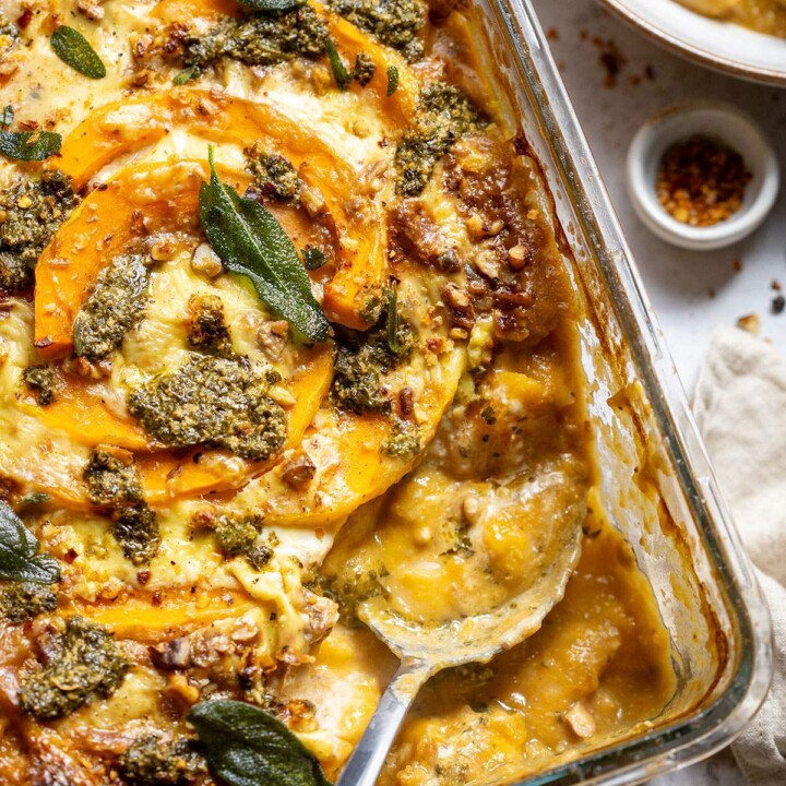 A serving spoon in a butternut squash gnocchi casserole dish.