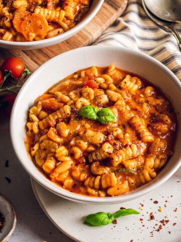 A bowl of plant based minestrone on the dinner table.