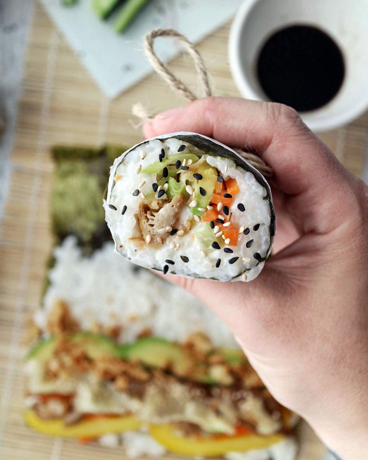 A hand holding a vegan sushi burrito.