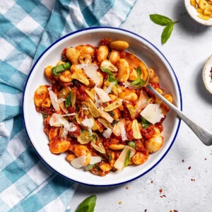Spicy arrabbiata beans on a plate with a spoon.