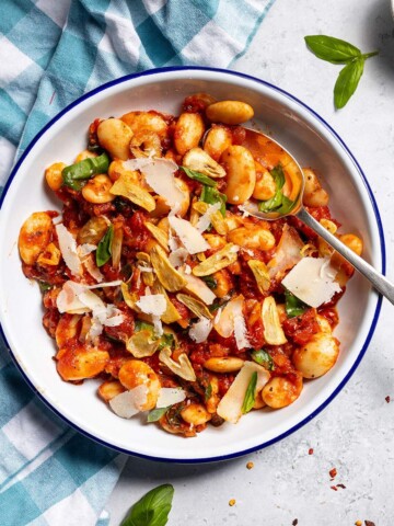 Spicy arrabbiata beans on a plate with a spoon.