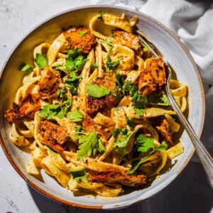 Creamy cajun alfredo with vegan cajun chicken pieces in a pasta bowl.