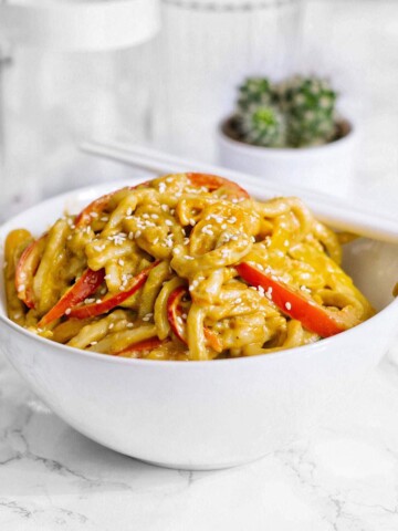 A bowl of high-protein vegan noodles on a table with chopsticks.