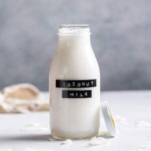 Homemade coconut milk in a glass bottle with a label.