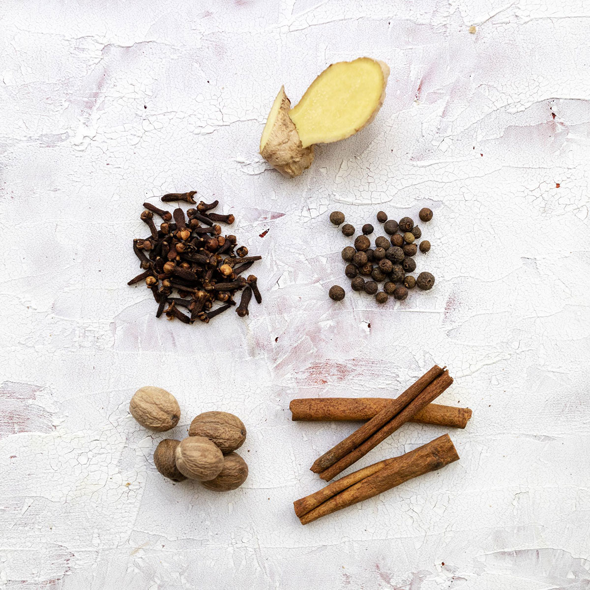 Ingredients for homemade pumpkin spice mix on a white table.