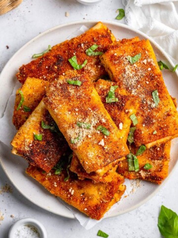 Crunchy vegan lasagna roll ups on a serving plate.