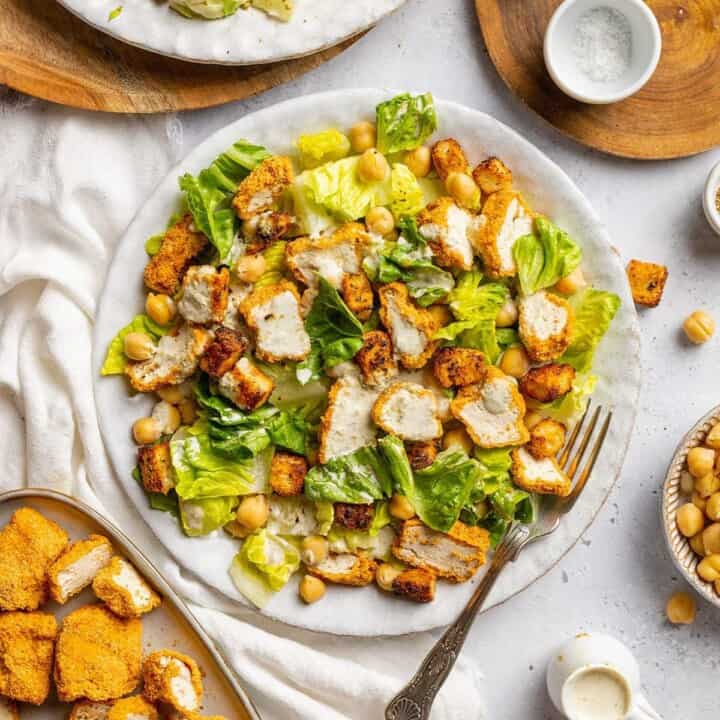 Vegan Caesar salad with crispy tofu pieces and chickpeas on a plate.