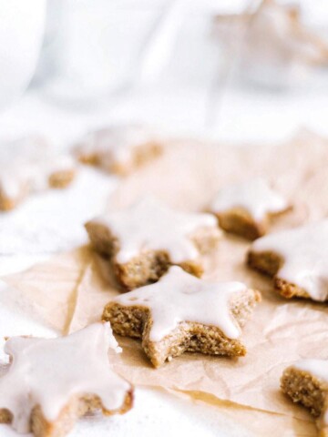 Vegan cinnamon cookies in star shape on a parchment paper.