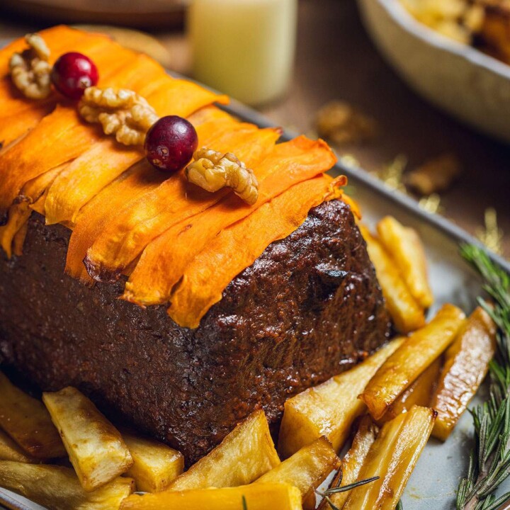 A vegan lentil and walnut nut roast decorated with carrot slices.