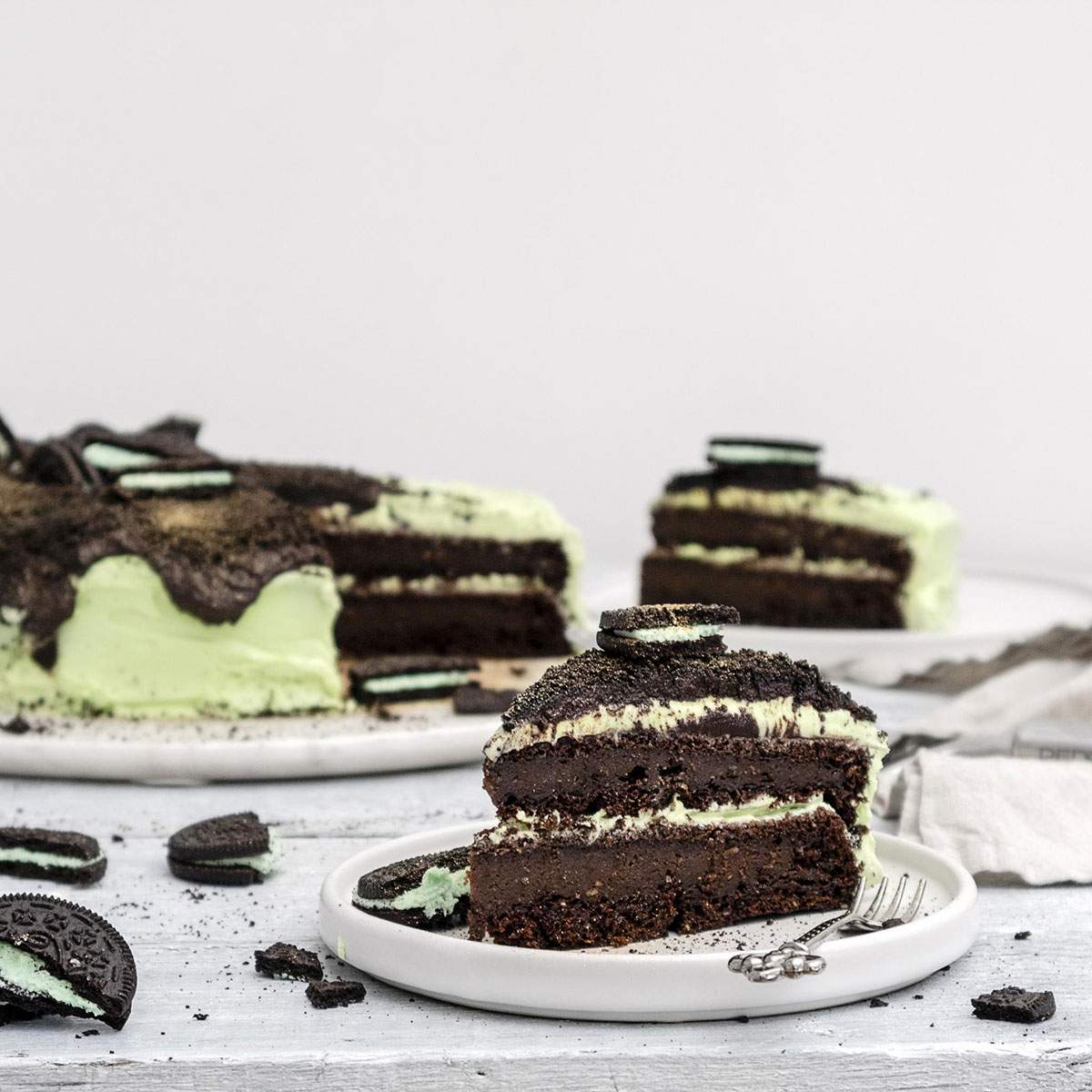 Slices of vegan oreo cake on a white table.