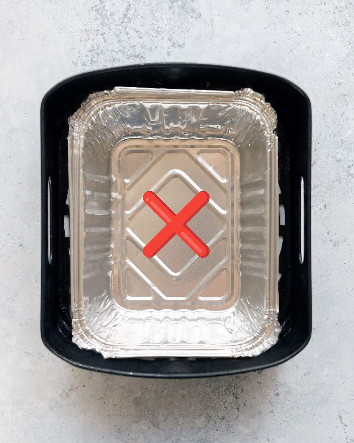 Incorrect use of an aluminum pan in the air fryer basket, covering all air holes.