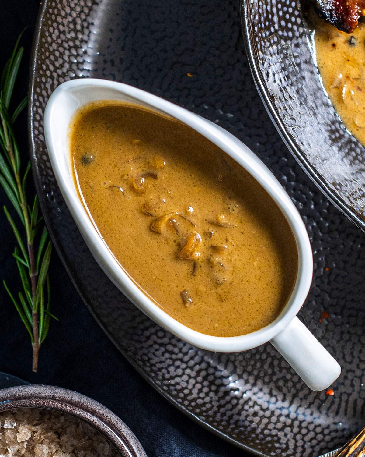 A gravy boat filled with a vegan peppercorn sauce.