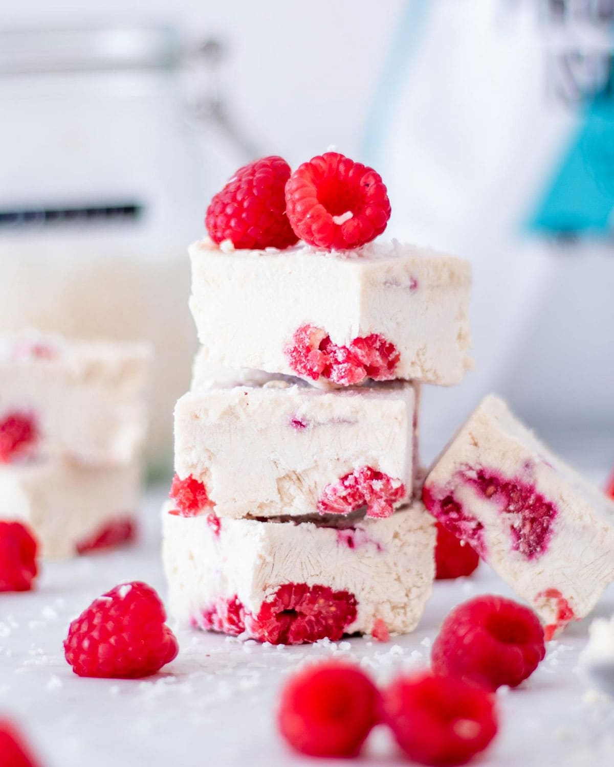 Three frozen yogurt protein bars with raspberries stacked on top of each other.