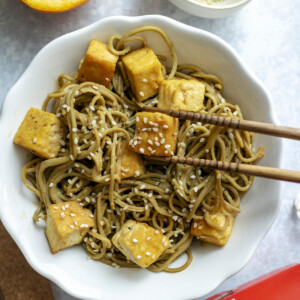 Sesame noodles in a serving bowl with tofu on top.