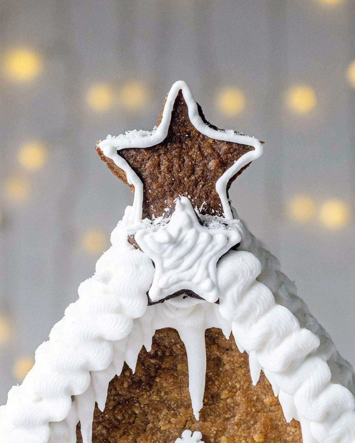 A gingerbread star on top of a vegan gingerbread house.