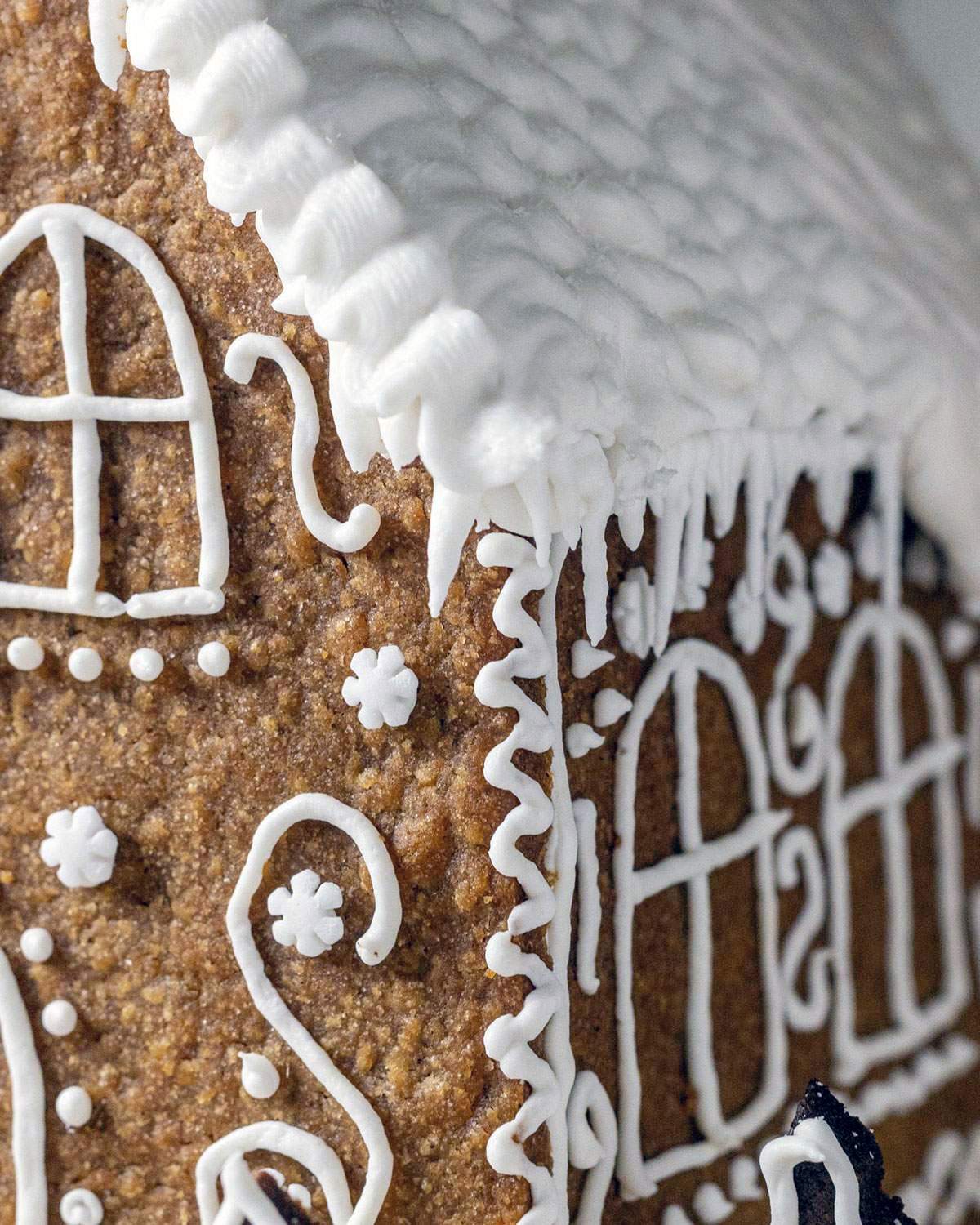 Vegan royal icing made with aquafaba on the roof of a gingerbread house.