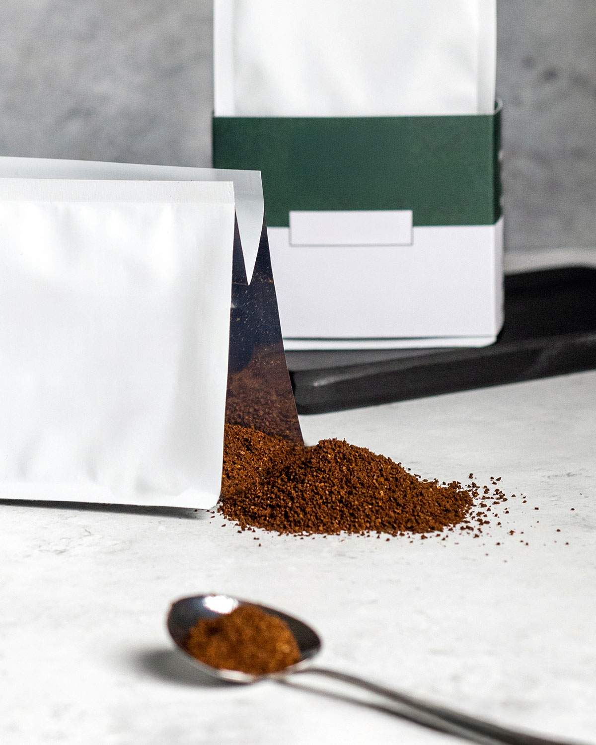 Coffee packaging with coffee grounds spilling from it.