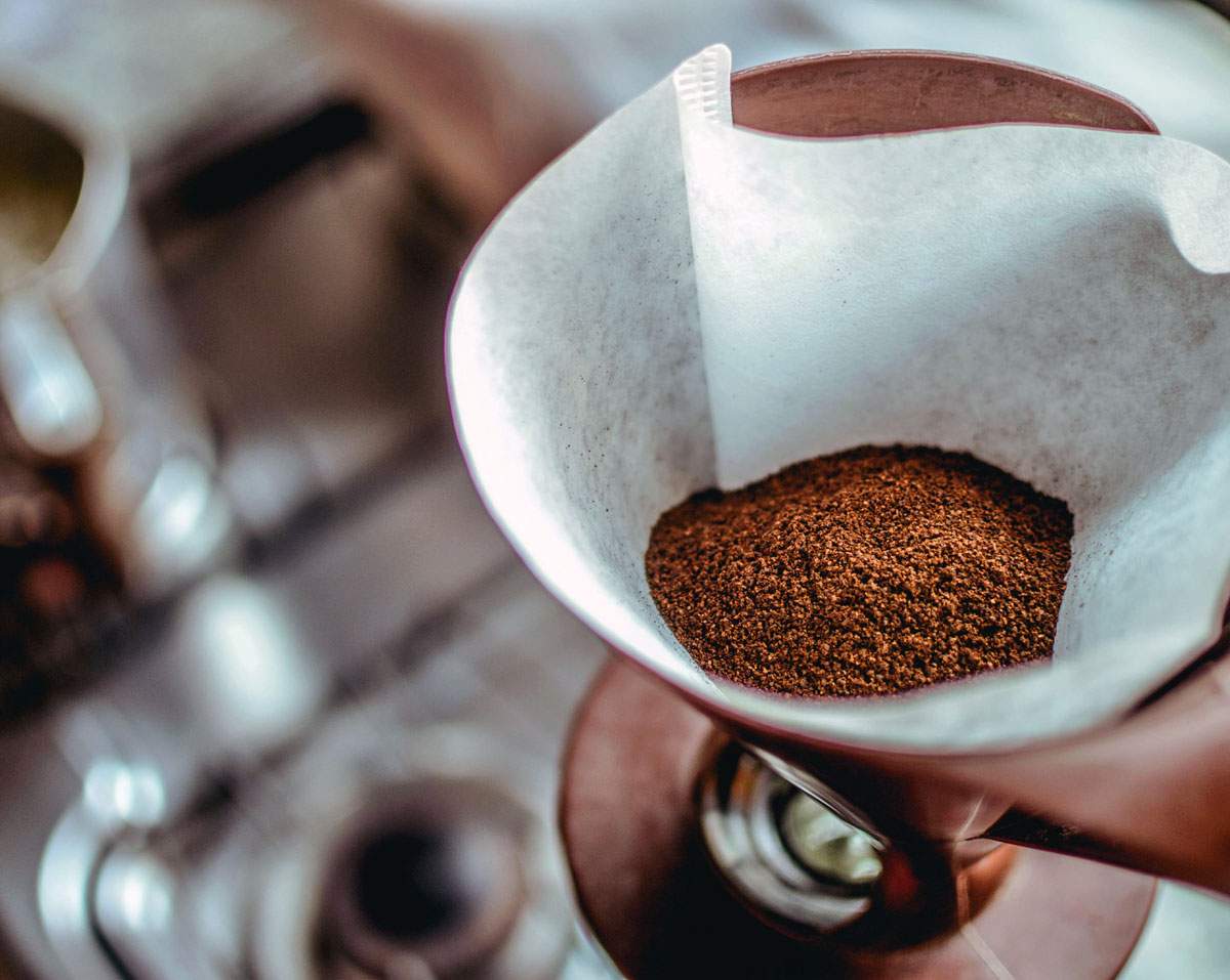 Coffee grounds in filter near kitchen sink.