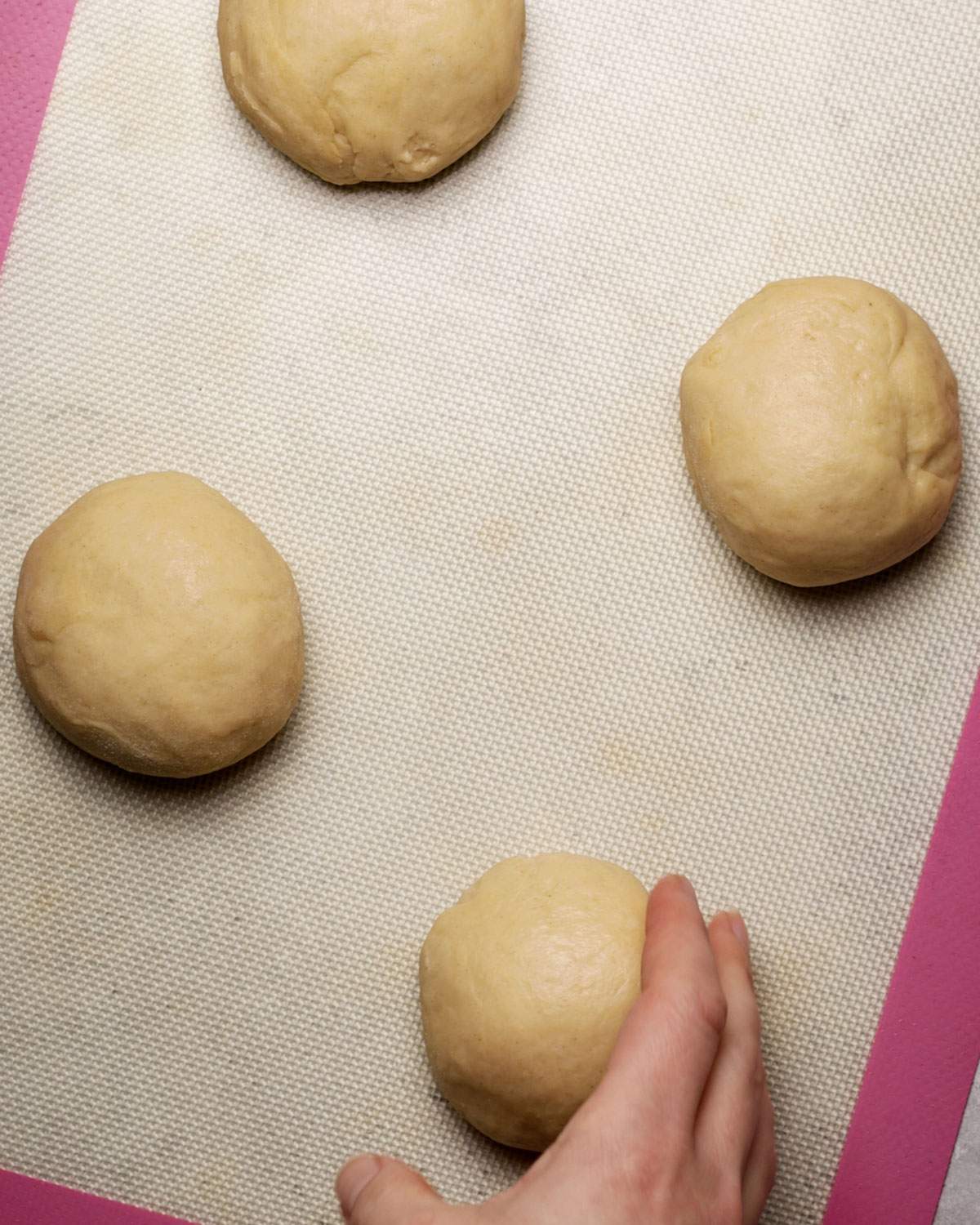 Placing dough balls on a baking mat.