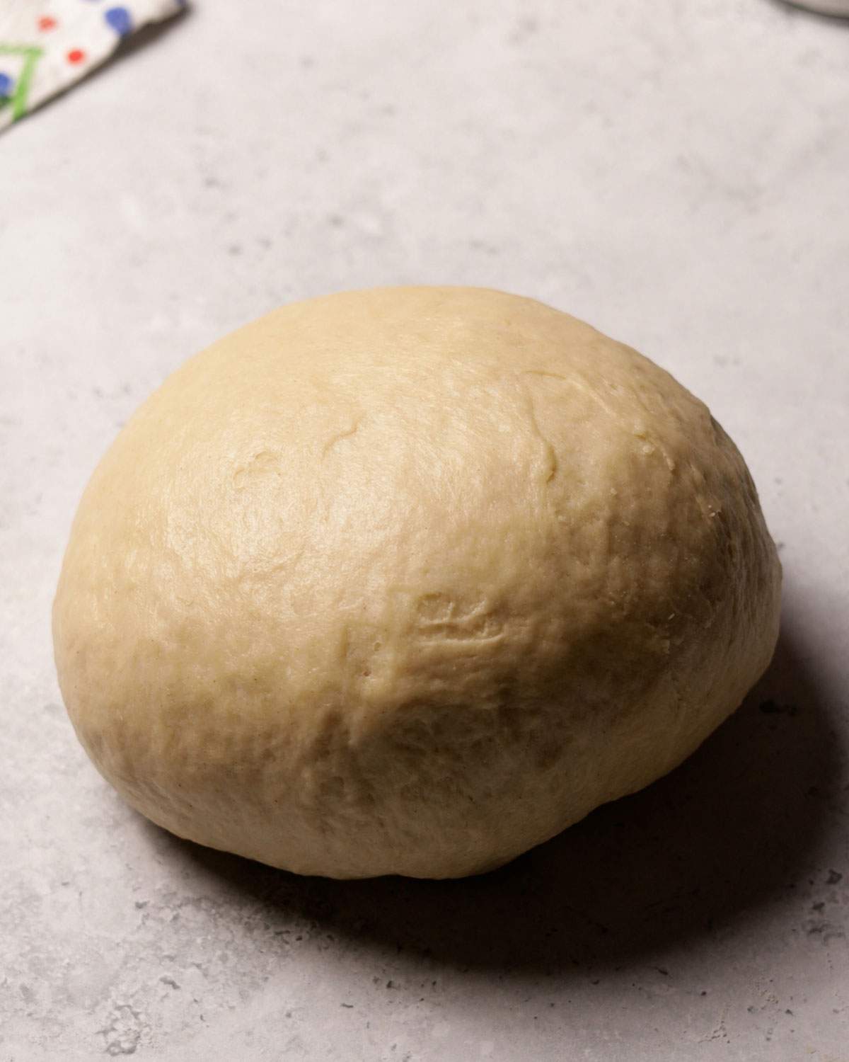 A smoothly kneaded dough ball on a kitchen counter.