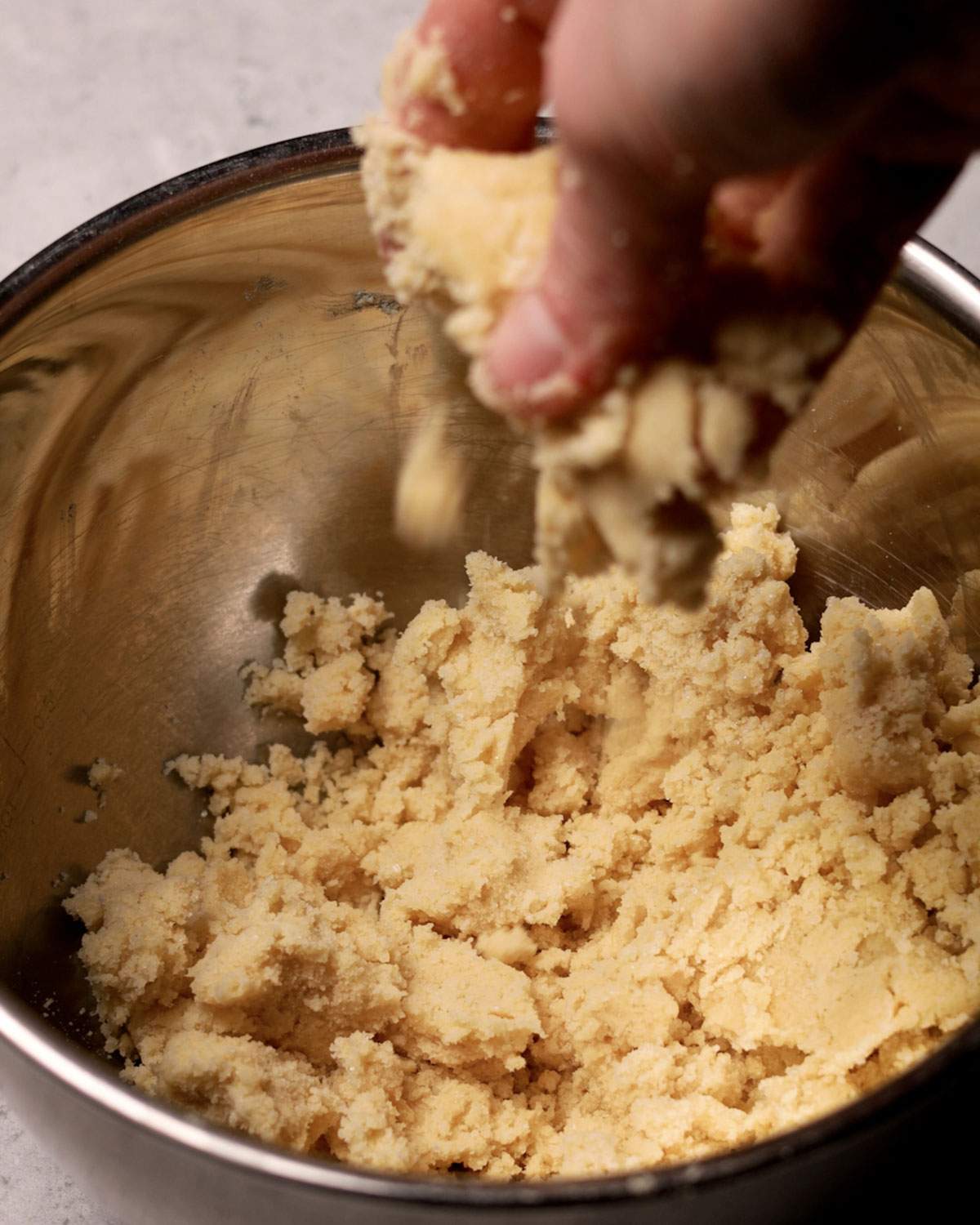 Mixing a crumble by hand in a bowl.