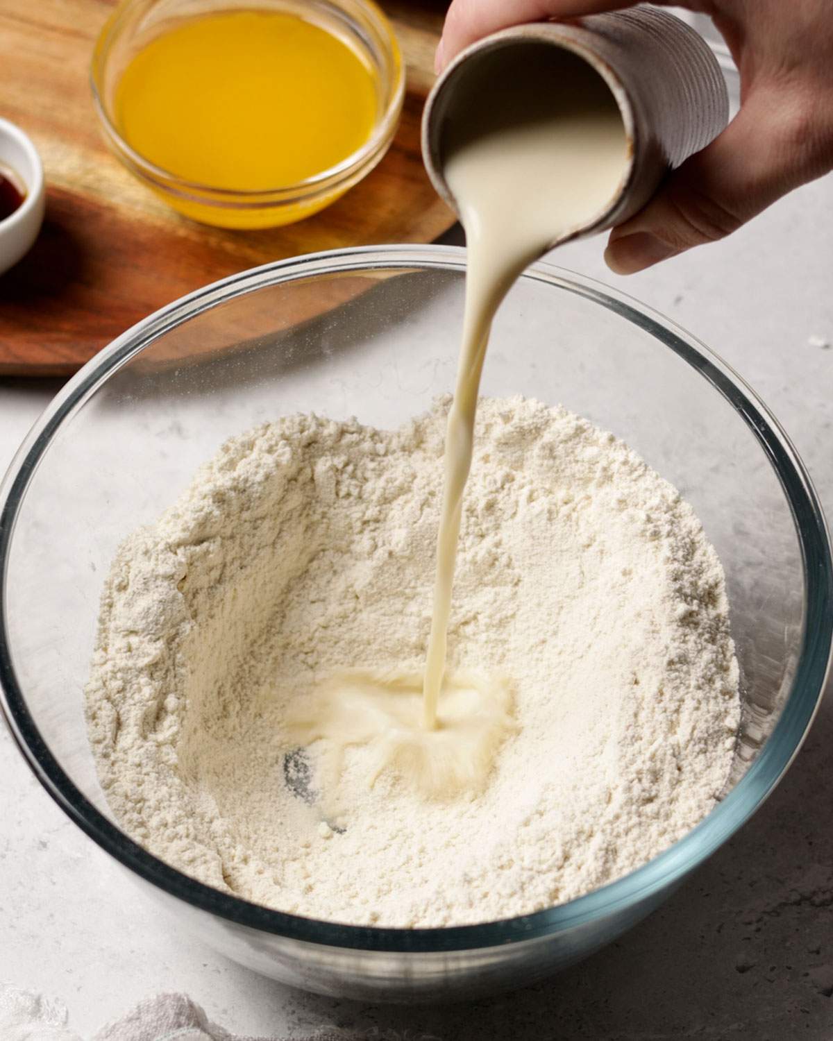 Pouring liquid ingredients into flour mix.
