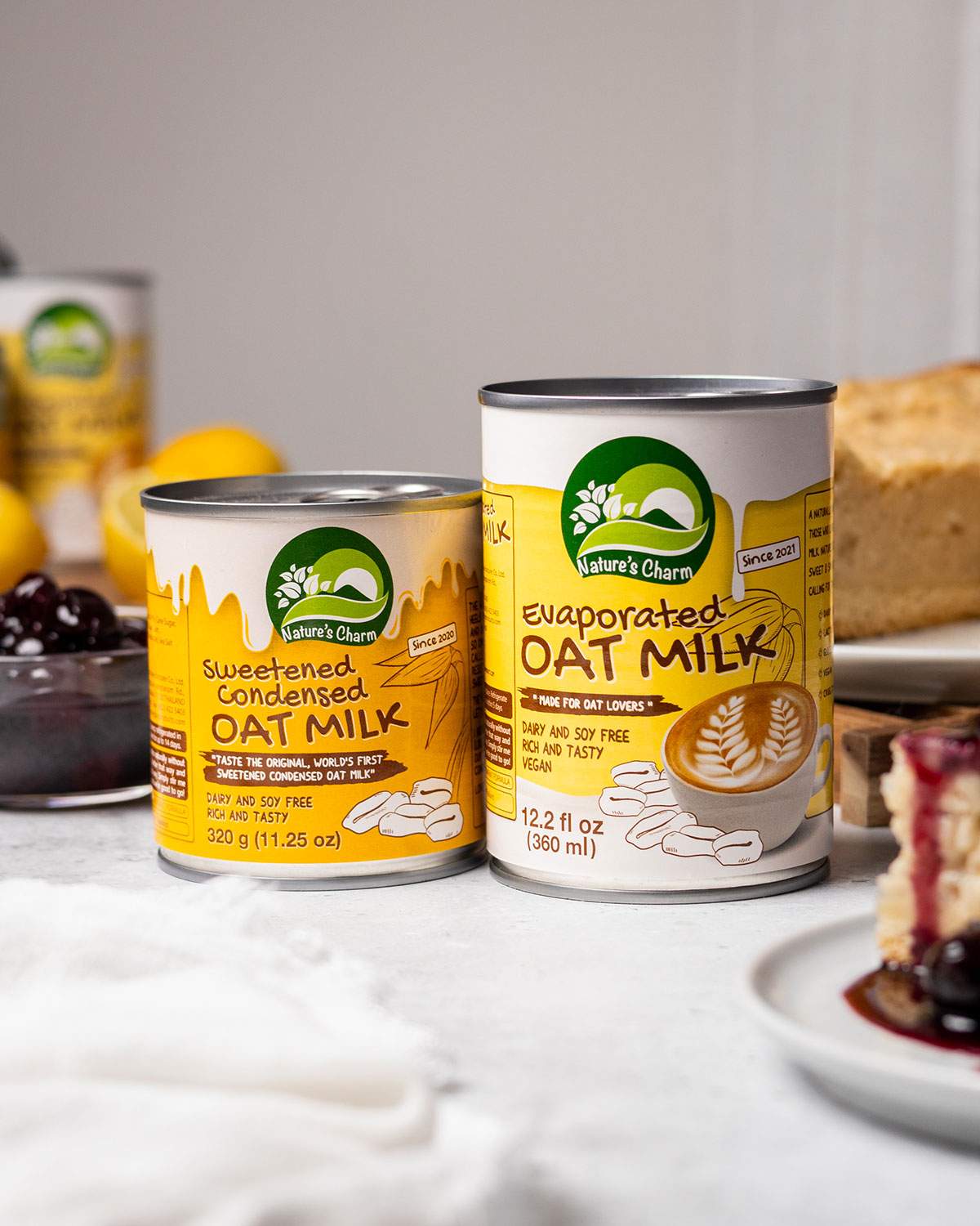 Cans of condensed oat milk and evaporated oat milk on a table.