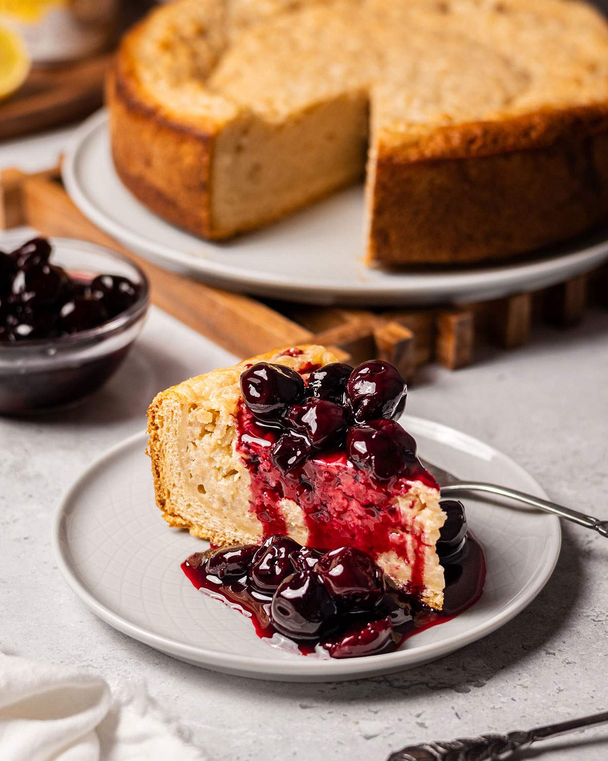 A slice of vegan Reisfladen with cherries on a serving plate.