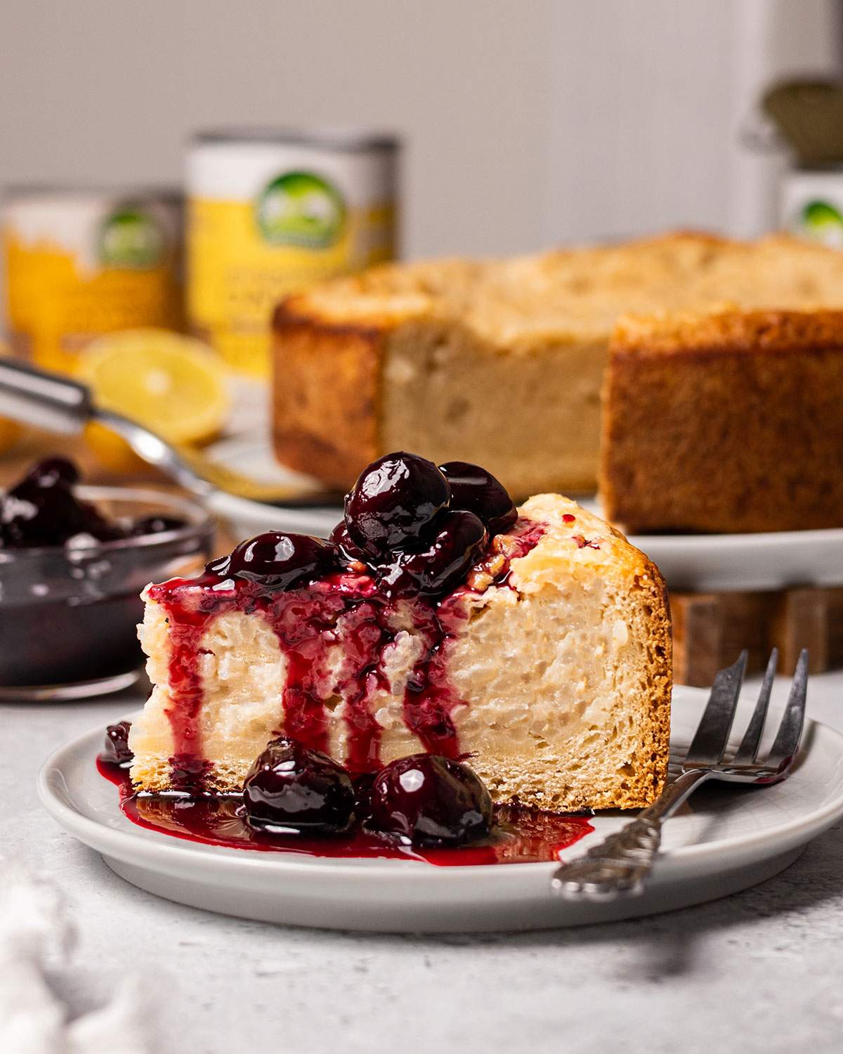A slice of vegan baked rice pudding cake aka vegan Reisfladen on a plate with cherries.