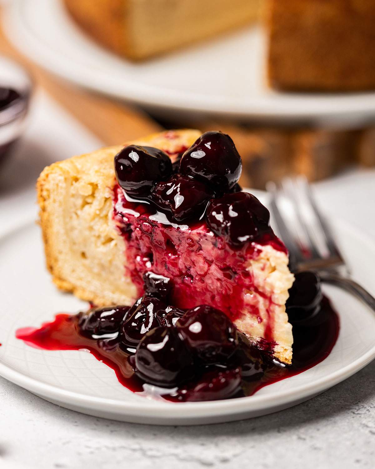 A slice of vegan Reisfladen with cherries on a serving plate.