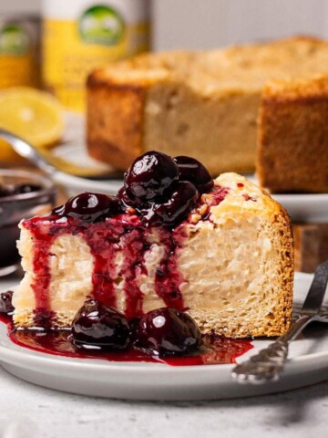 A slice of vegan baked rice pudding cake aka vegan Reisfladen on a plate with cherries.