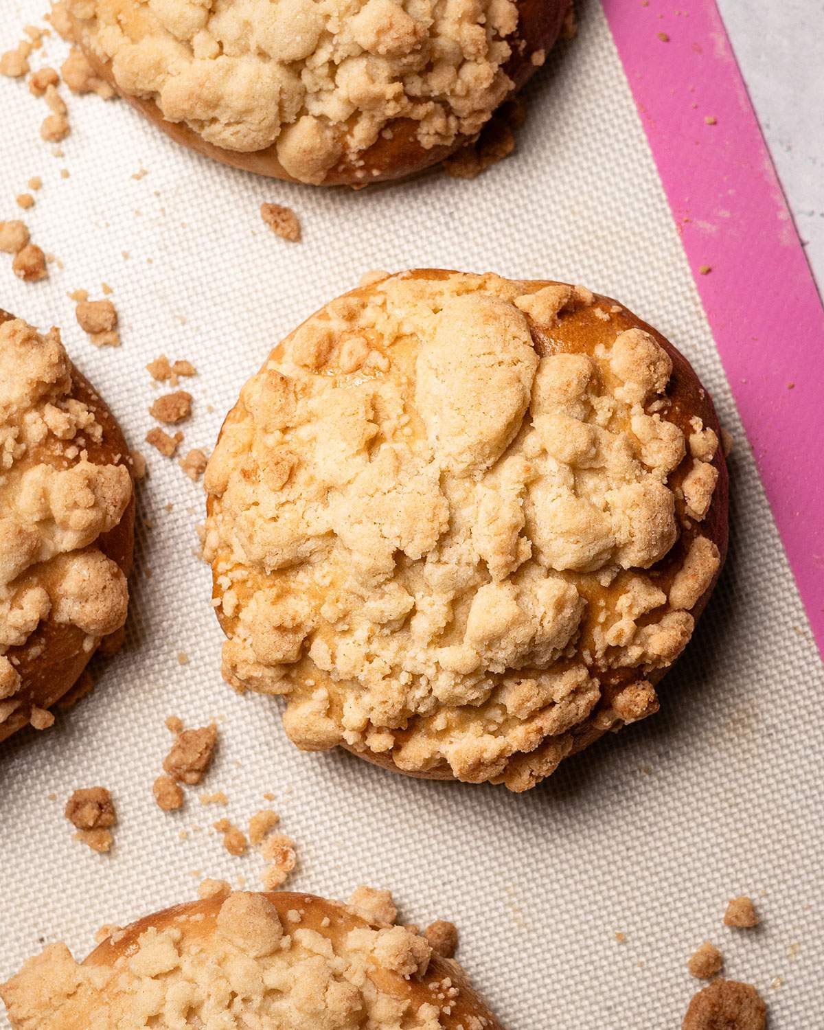 Freshly baked crumble rolls aka Streuselbrötchen on a baking mat.
