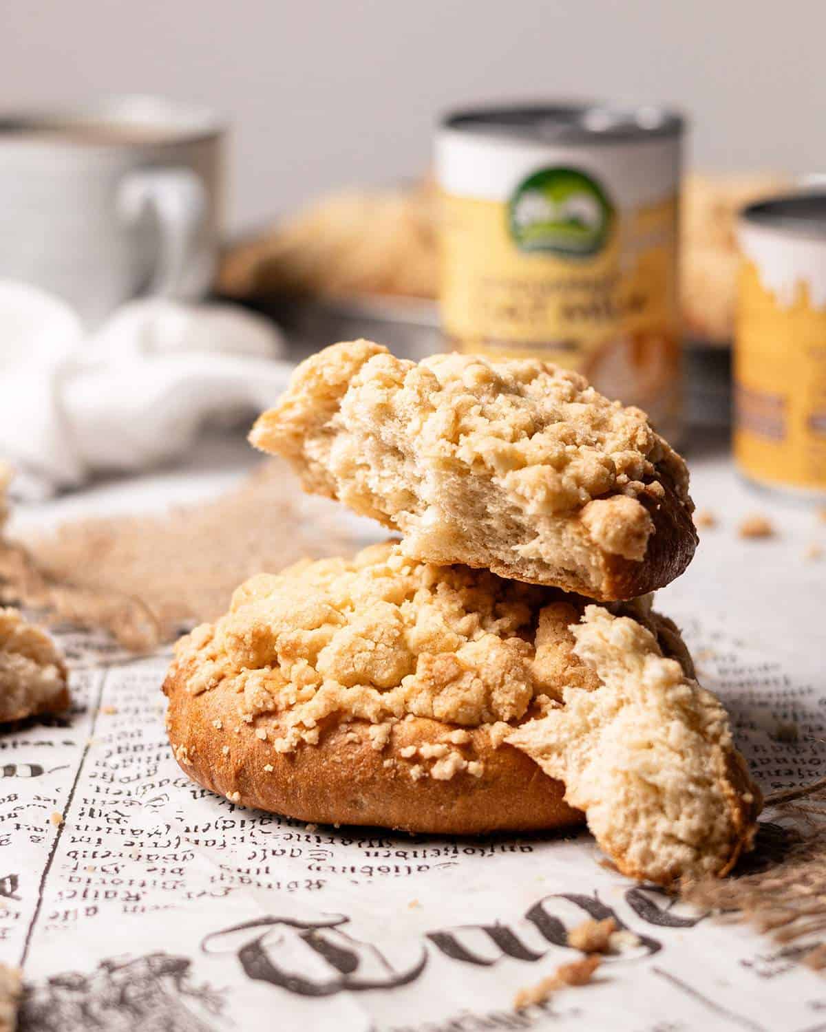 Two crumble rolls stacked with a piece torn off the one on top.