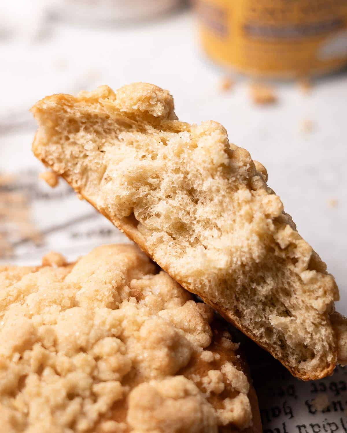 A torn crumble roll (Streuselbroetchen) showing the fluffy texture inside.