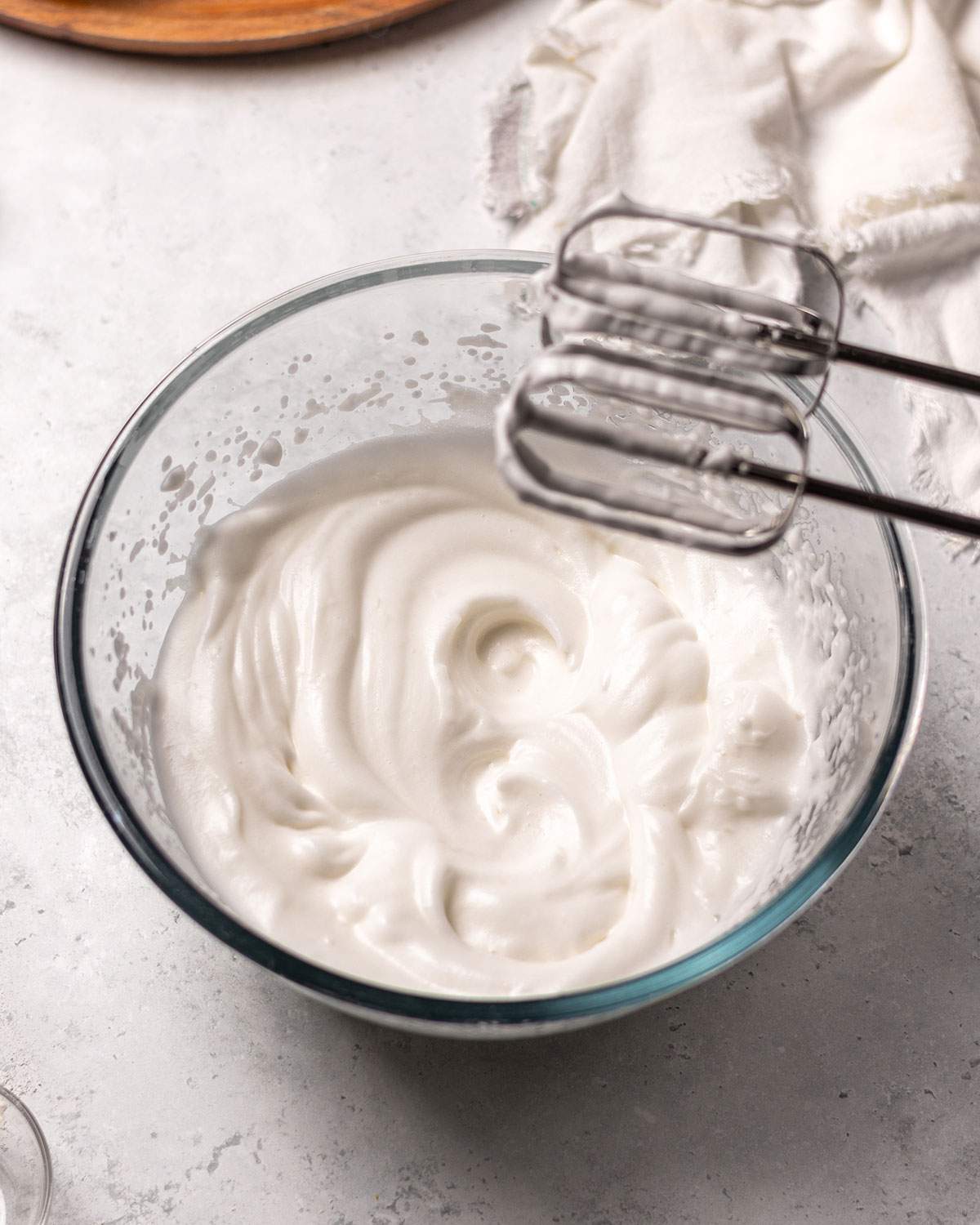 Whipped aquafaba with stiff peaks in a glass bowl.