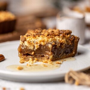 Close up of vegan date caramel tart slice with crumble topping.