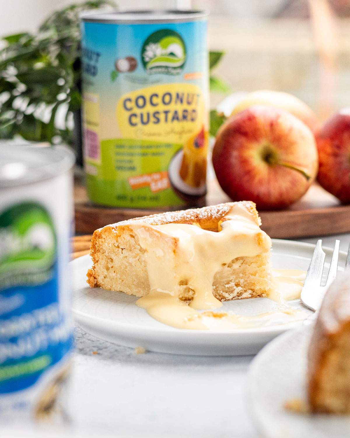 Close-up of vegan German apple cake slice topped with creamy vegan custard on a white plate.